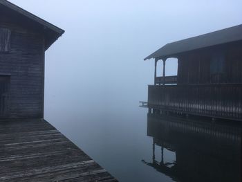 Building by lake against sky