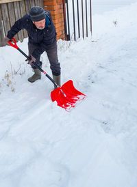 Senior man cleaning snow on street