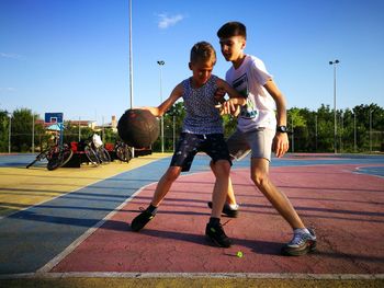 Full length of friends on street against sky