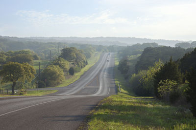 Road amidst trees against sky