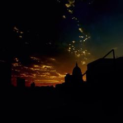 Silhouette of buildings against sky at sunset