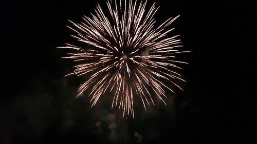 Low angle view of fireworks in sky at night