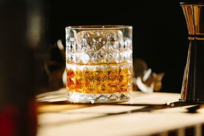 Close-up of glass with bourbon whiskey on table