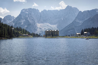 Scenic view of lake by snowcapped mountains against sky