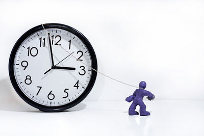 Rear view of man painting clock on white background