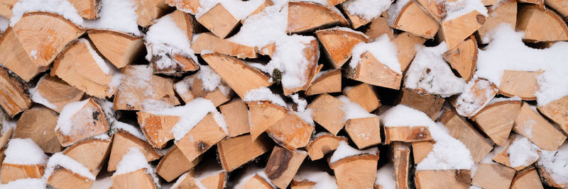 Textured firewood background chopped wood for kindling and heating. woodpile with stacked firewood