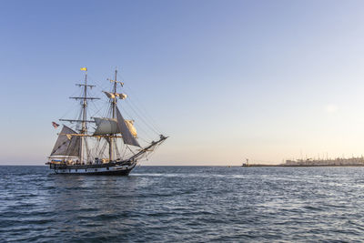 Sailboat sailing in sea against clear sky