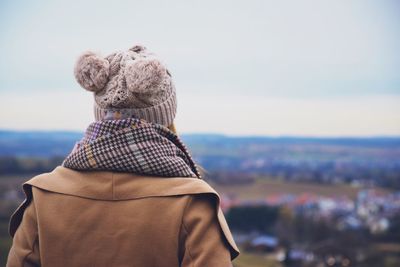 Rear view of woman in warm clothing against sky