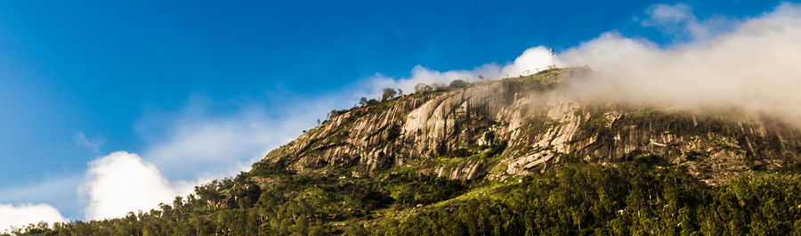 Low angle view of mountain against blue sky