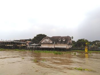 Building by river against sky