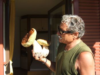 Close-up of man holding mushroom at home