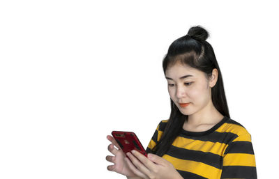 Young woman using smart phone against white background