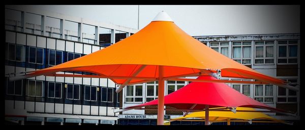 Multi colored umbrella against sky in city