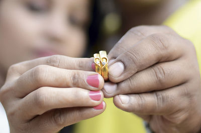 Close-up of couple holding finger rings
