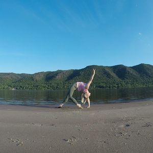 Full length of horse on beach against clear blue sky