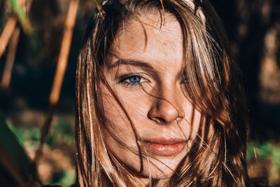 Close-up portrait of young woman in sunny day