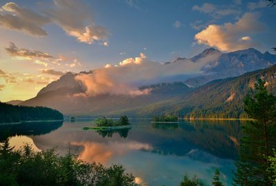 Scenic view of lake and mountains against sky at sunset