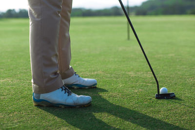 Low section of person standing on golf course