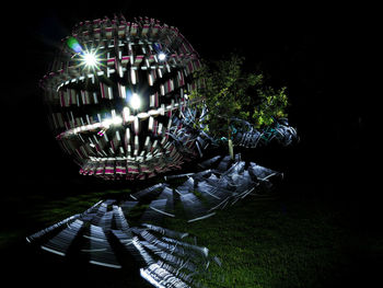 Close-up of illuminated lighting equipment against black background