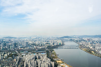 High angle view of river amidst buildings in city against sky