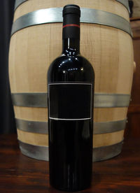 Close-up of wine bottle against barrel