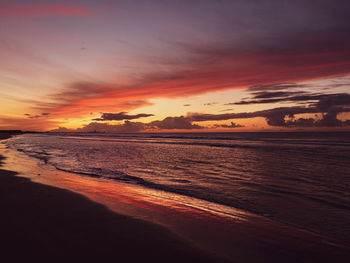 Scenic view of sea against dramatic sky during sunset