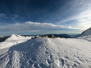 Snow covered landscape against sky