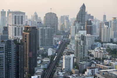 Aerial view of buildings in city against sky