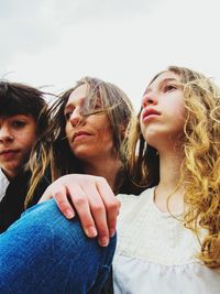 Portrait of young woman, young girl and young boy looking away against sky