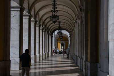 Rear view of people walking in corridor of building