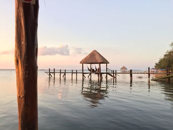 Wooden posts on pier over sea against clear sky