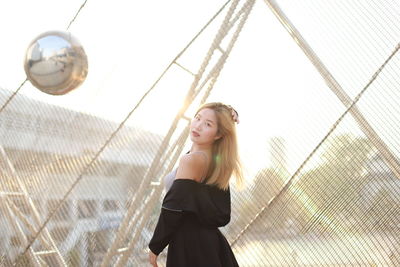 Rear view of young woman standing in boat