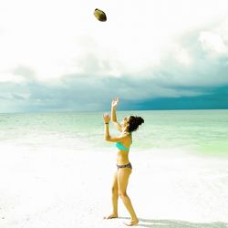 Silhouette of woman jumping on beach