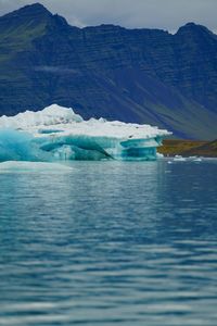 Scenic view of lake and iceberg against mountain