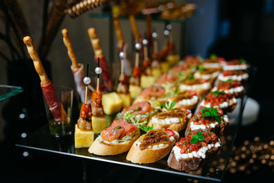 Hors d'oeuvres on a glass table. salsa, salmon, tomatoes, mozzarella, and cheese canapes.