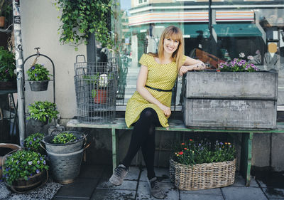 Woman standing by potted plants in basket