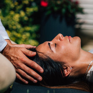 Woman in reiki spiritual healing session. reiki therapist holding hands above heart chakra 