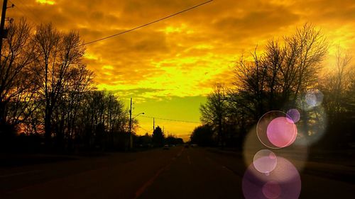 View of illuminated street lights against cloudy sky