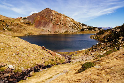 Scenic view of lake by mountain against sky