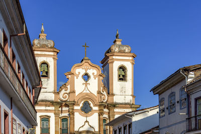 Facade of historic colonial style house and church in the famous city of ouro preto