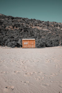 House on mountain by road against sky