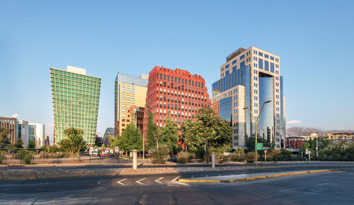 Buildings in city against clear blue sky