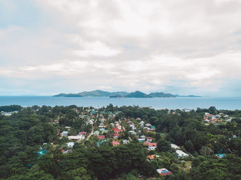 High angle view of townscape by sea against sky