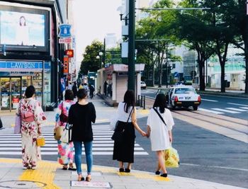 Rear view of people walking on road