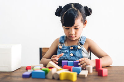 Cute girl playing with toy on table