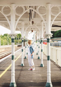 Full length of woman standing at railroad station platform