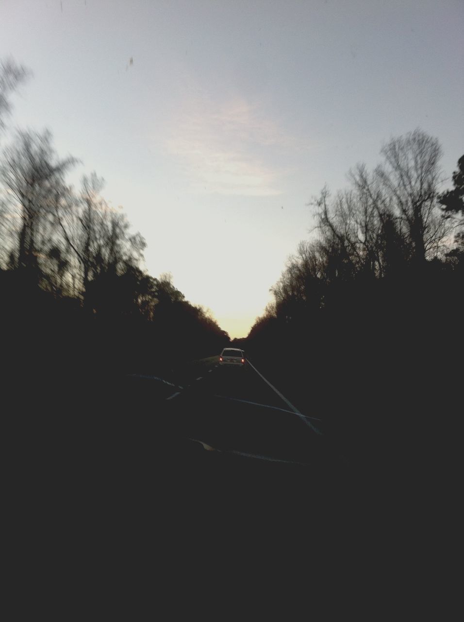 transportation, tree, silhouette, sky, road, the way forward, mode of transport, bare tree, land vehicle, car, sunset, diminishing perspective, railroad track, no people, vanishing point, dusk, outdoors, nature, tranquility, street