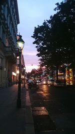 Illuminated buildings in city at sunset