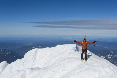 A man climbs to the summit of mt. hood in oregon.