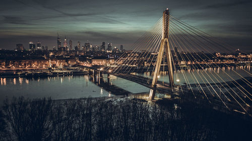 Bridge over river in city at night